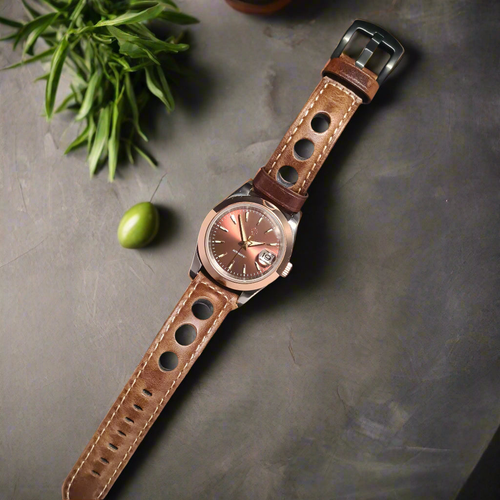 Wristwatch with brown leather strap on a dark gray background