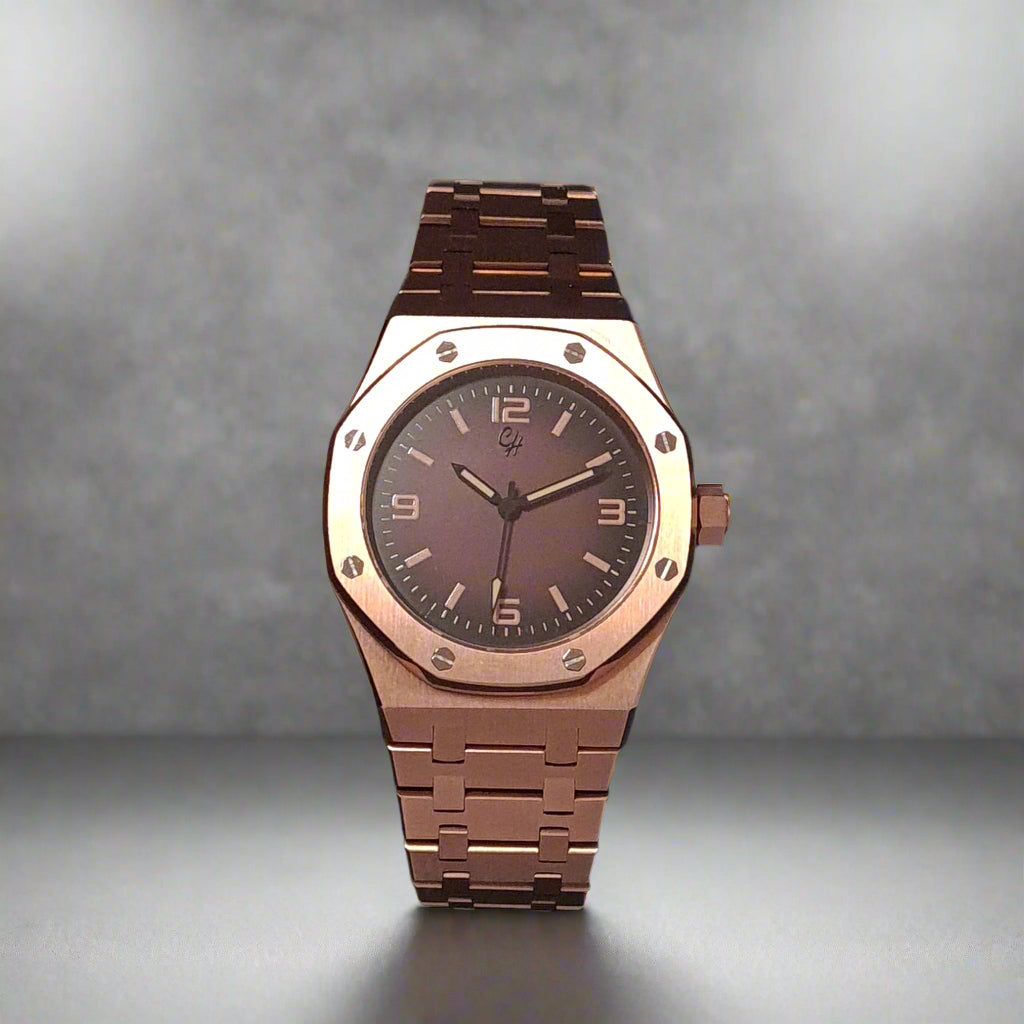Rose gold watch with dark face on a grey background