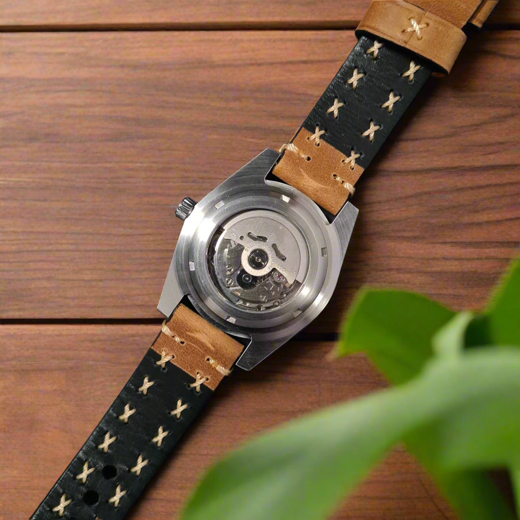 Watch with a brown leather strap featuring star patterns oak table