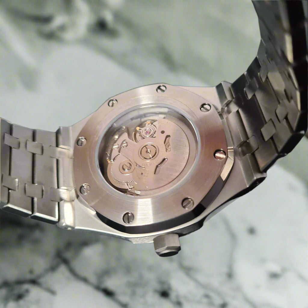 Close-up of a silver watch with a detailed mechanism on a marble surface