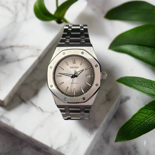 Silver watch with a dark face on a gray background