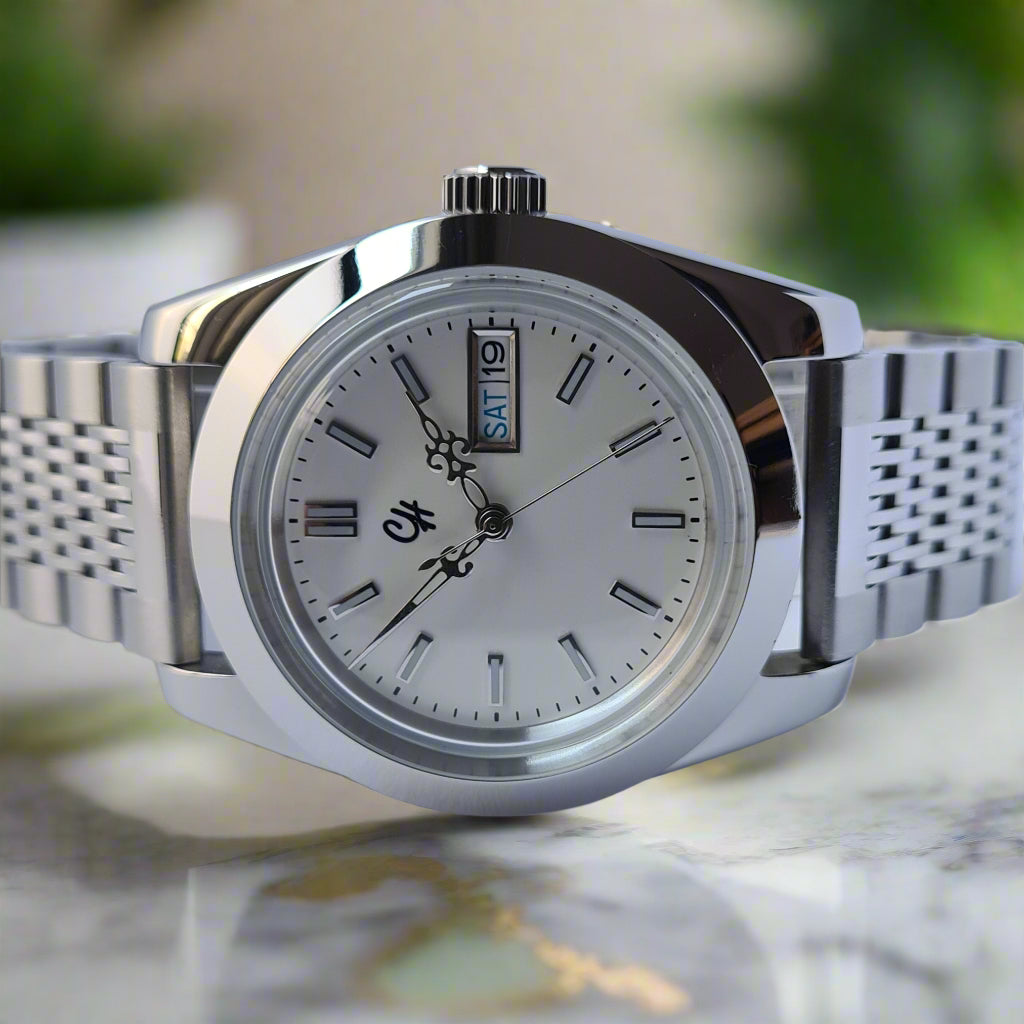 Silver wristwatch with a white face on a light gray background