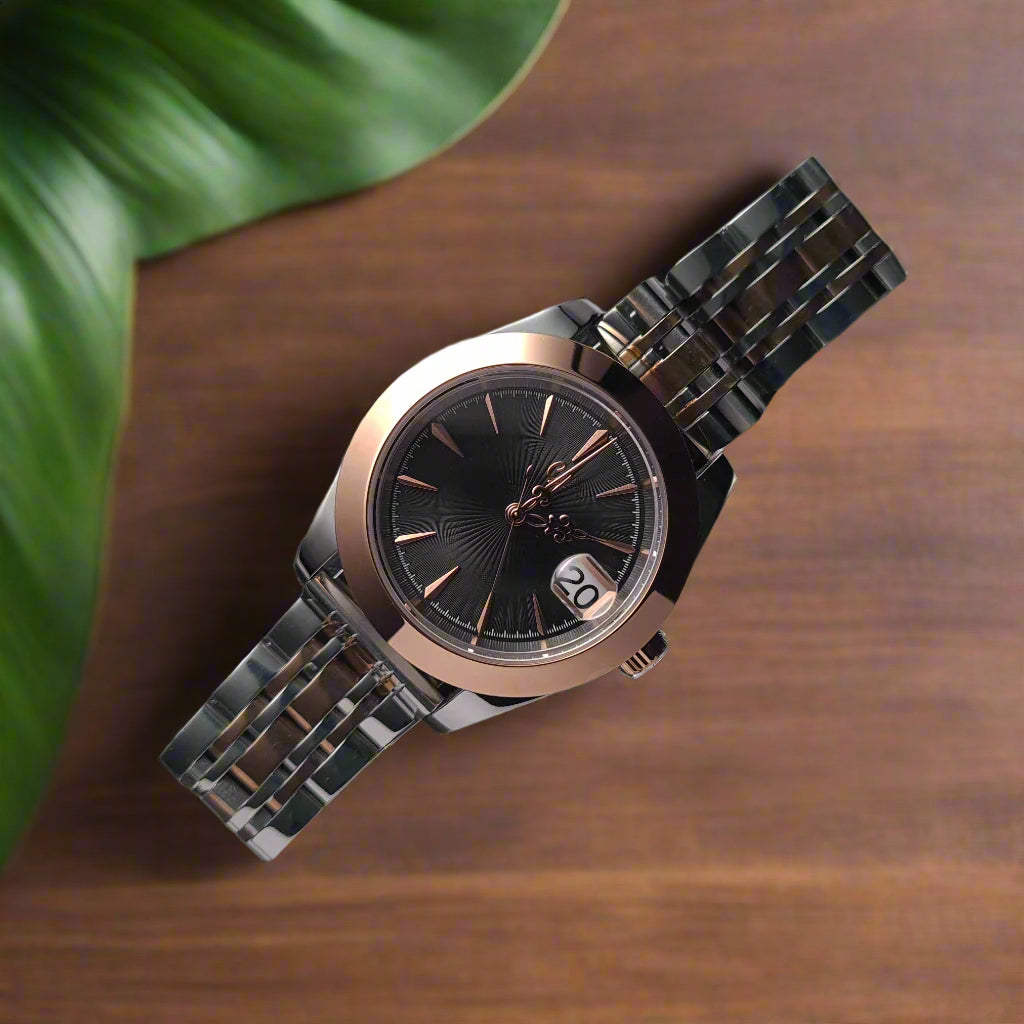 Silver watch with a black face on a dark textured surface