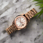 Rose gold watch on a dark textured fabric background