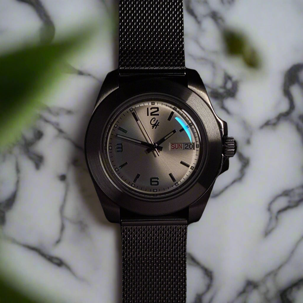 Black wristwatch with a dark mesh band on a black background