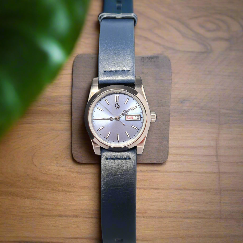 Wristwatch with blue leather strap on a wooden surface