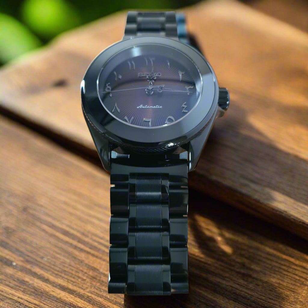 Black watch with a metallic band on a wooden surface