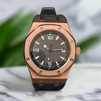 Rose gold watch with black dial on marble bench top