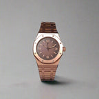 Rose gold watch with dark face on a grey background