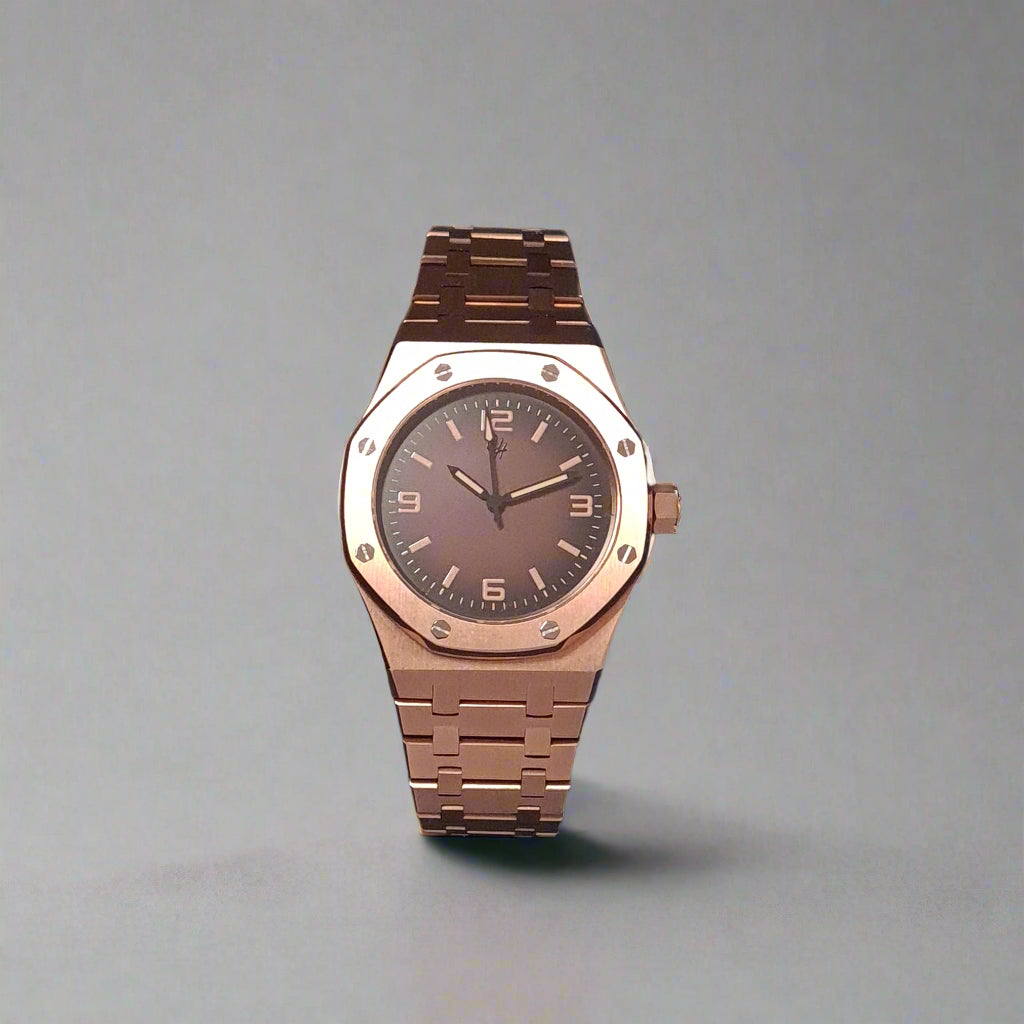 Rose gold watch with dark face on a grey background