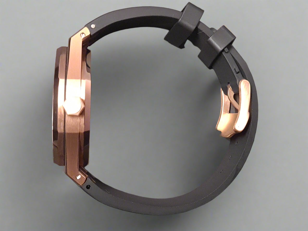 Black and rose gold watch case on a gray background