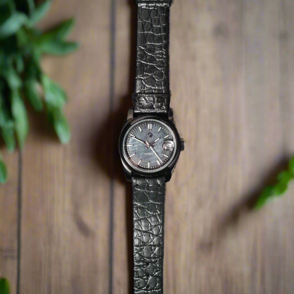 Black wristwatch with a textured strap on a kitchen table background