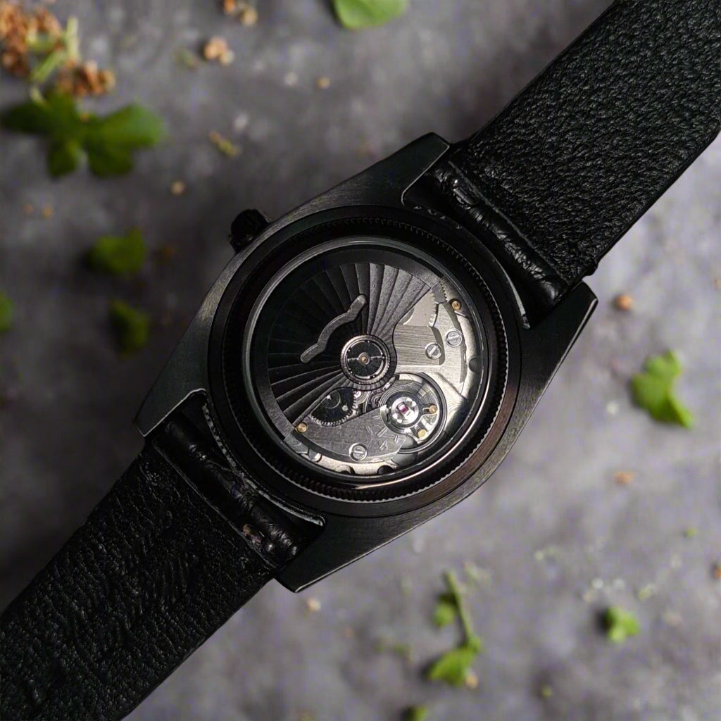 Black wristwatch with open face design on a dark background