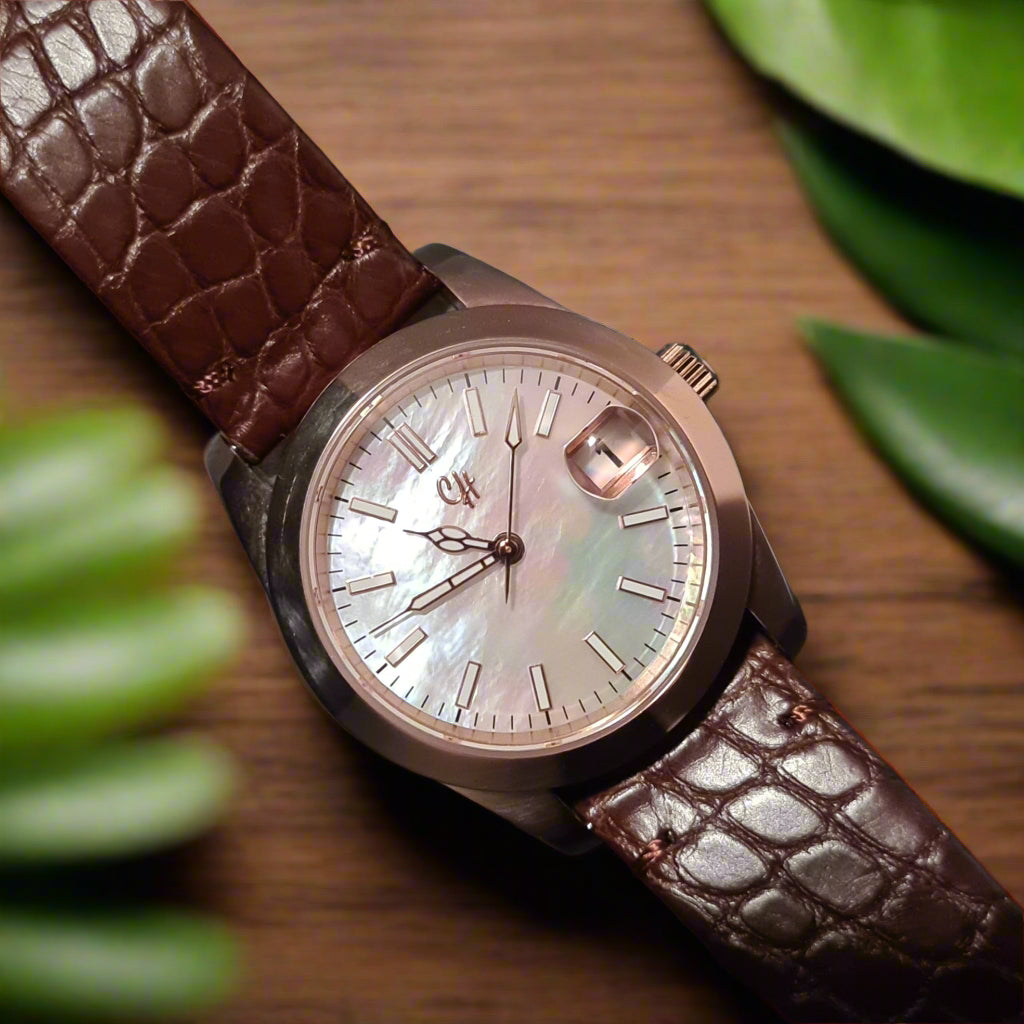 This watch features a vibrant pearl shell dial with a captivating sunburst finish, accented by applied indices and sleek silver hands, complete with a date window at 3 o'clock.
