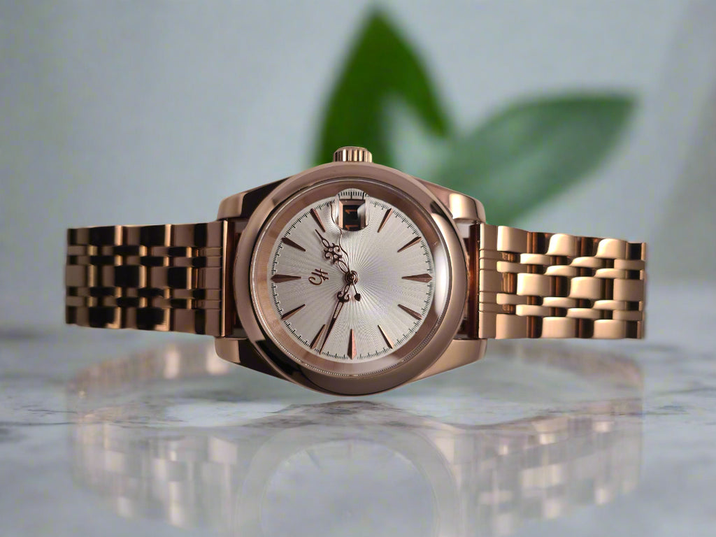 Rose gold watch with a silver face on a light gray background
