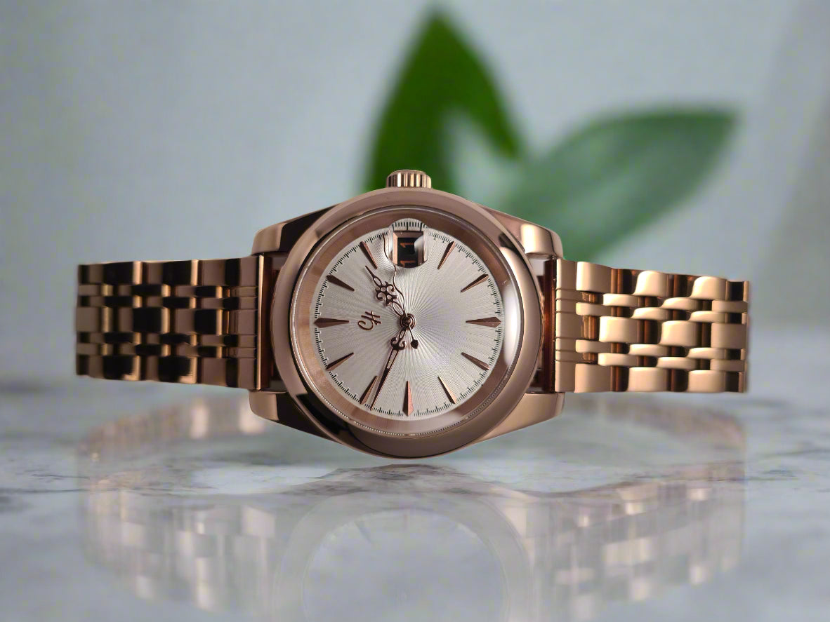 Rose gold watch with a silver face on a light gray background