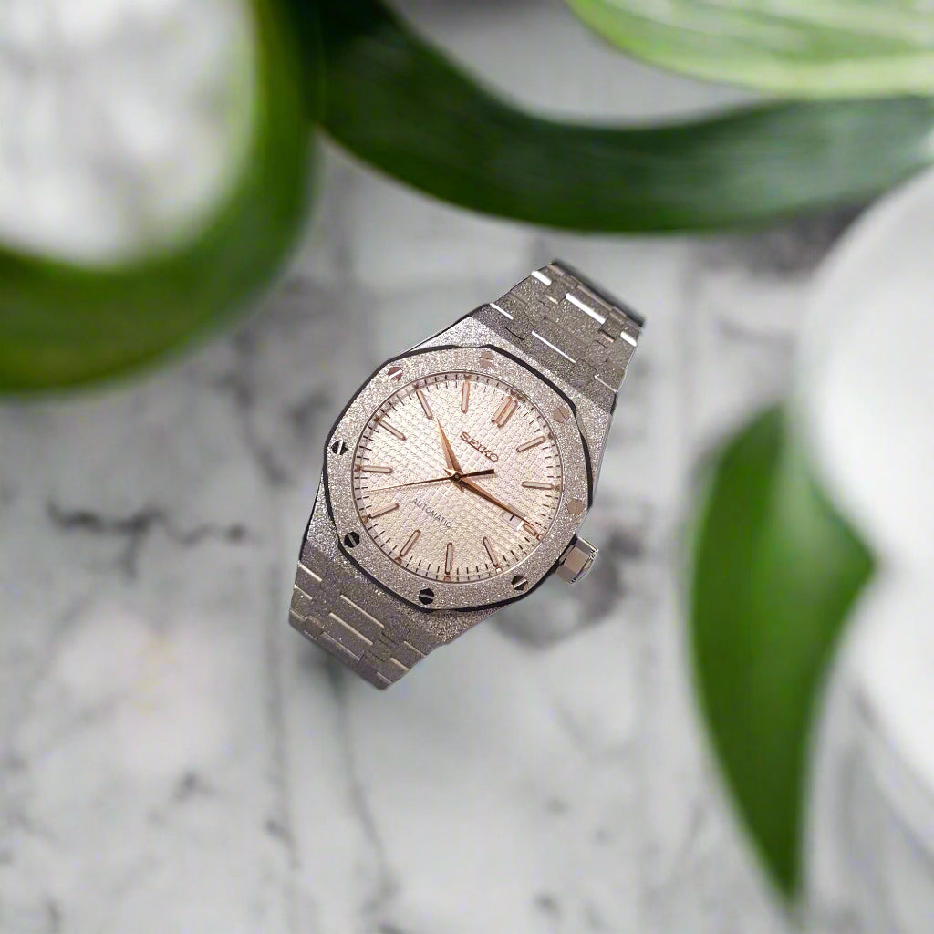 Silver wristwatch with a detailed face marble bench