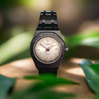 Wristwatch with black strap and beige dial on oak table