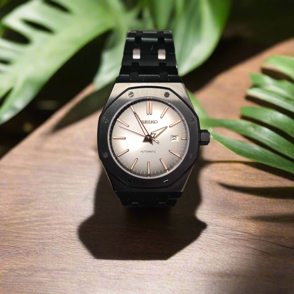 Wristwatch with a black strap and silver dial on a table