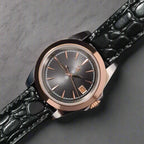 Luxury watch with black crocodile leather strap on a dark background