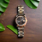 Silver and rose gold watch on a dark gray background