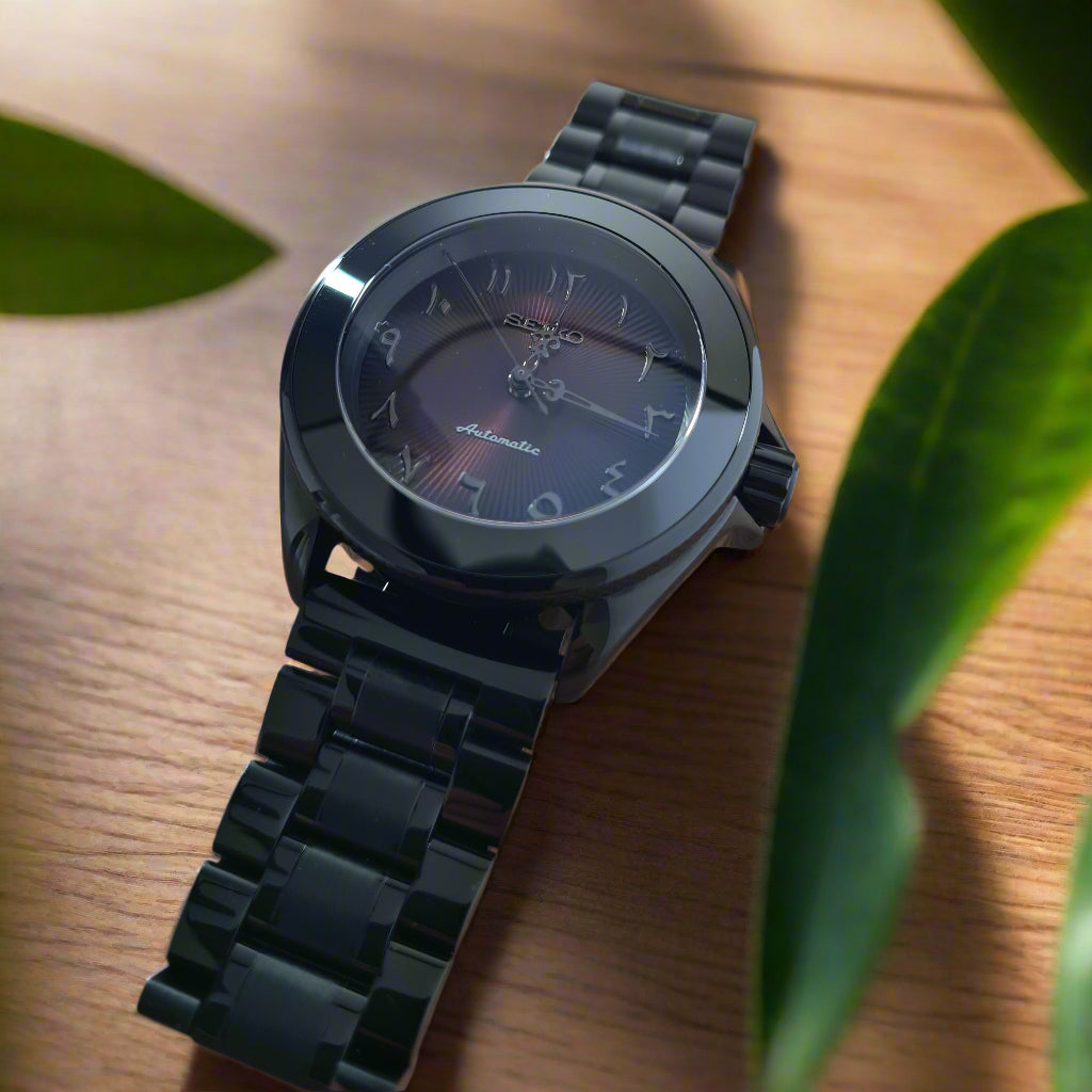 Black wristwatch on a wooden surface