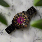 Watch with a purple face and black metal strap on a dark background