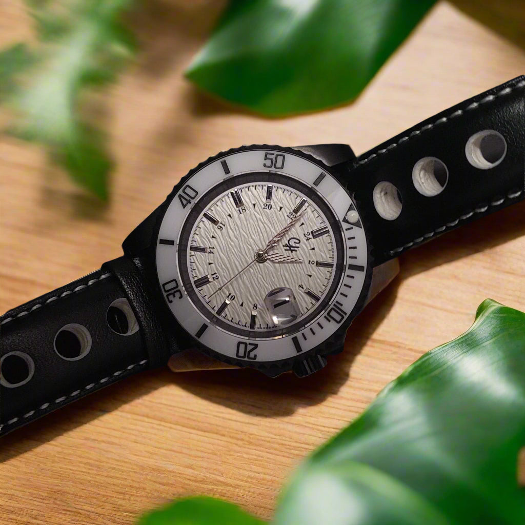 Wristwatch with black leather strap and white dial on a dark background
