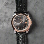 Wristwatch with black strap and rose gold case on a dark background