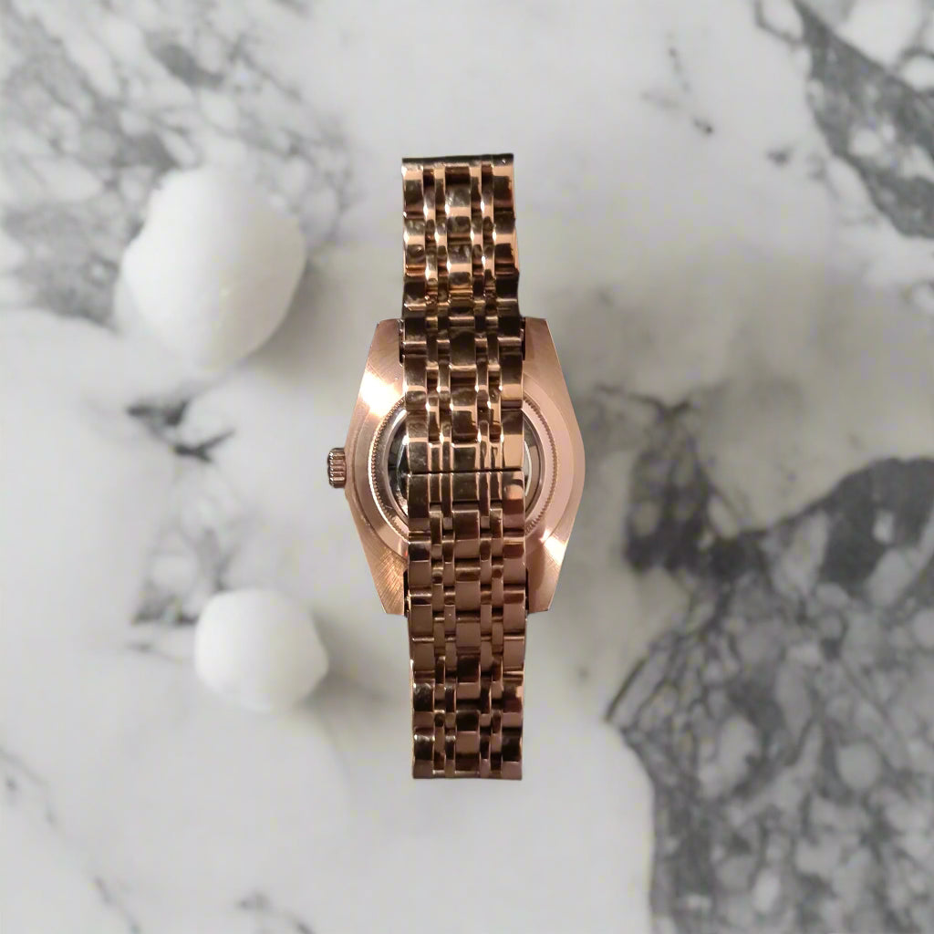 Rose gold watch on a dark gray background