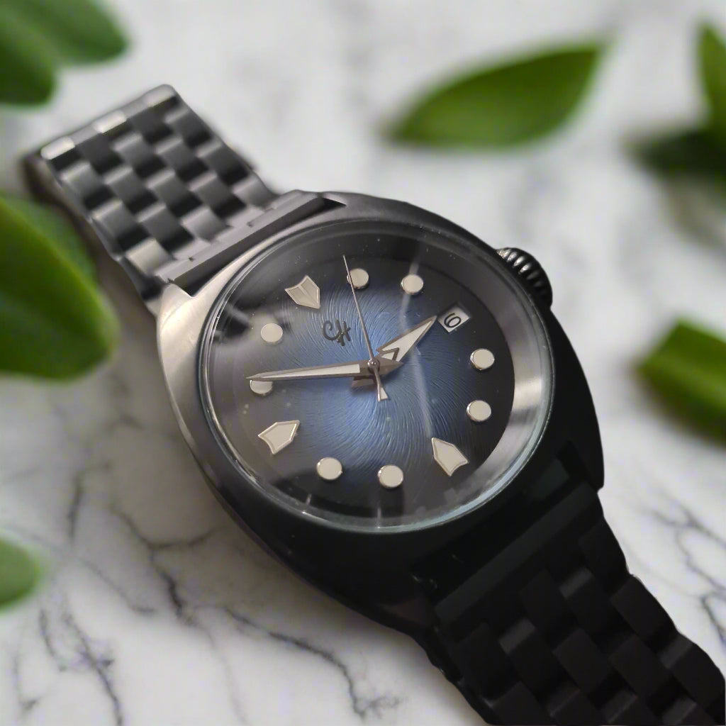 Black wristwatch with a dark face on a gray background