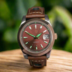Watch with brown leather strap and reddish-brown dial on a dark background