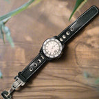 Black wristwatch with a detailed face on a wooden surface