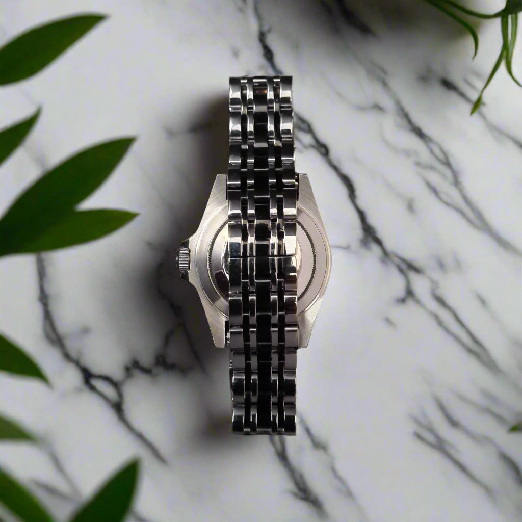 Metallic watch on a marble table