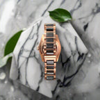 Rose gold watch with black band on a dark gray background