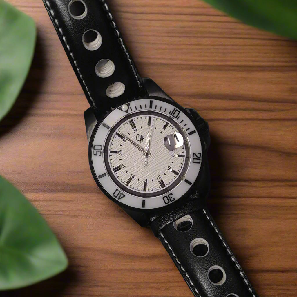Watch with black leather strap and white face on a dark background