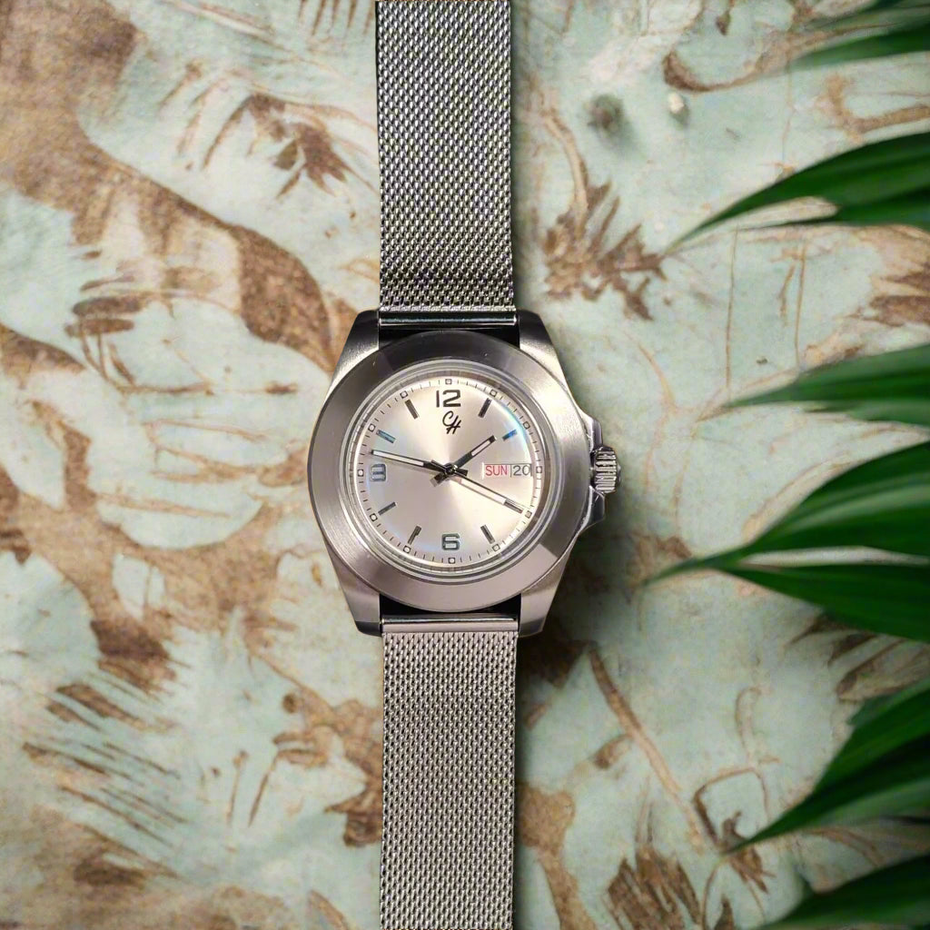 Silver watch with a mesh band on a dark background